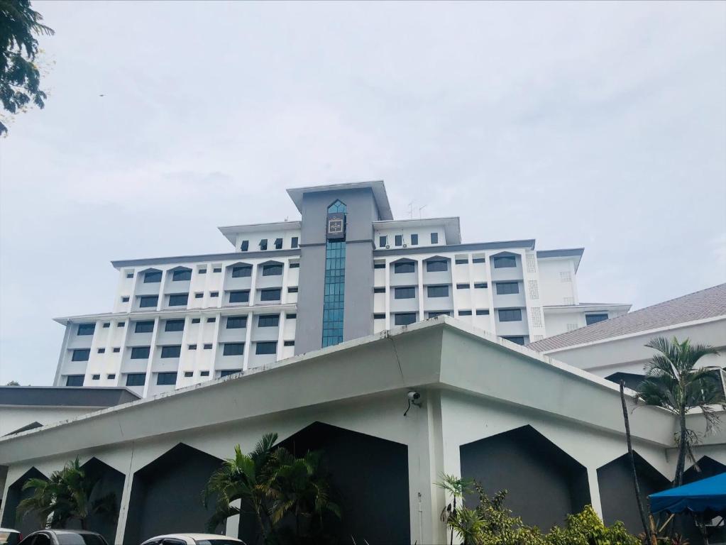 duży biały budynek z wieżą zegarową na górze w obiekcie Raia Hotel Kota Kinabalu w mieście Kota Kinabalu