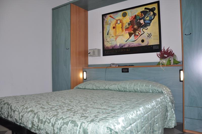 a bedroom with a bed and a tv on the wall at Hotel Bristol in Tirrenia