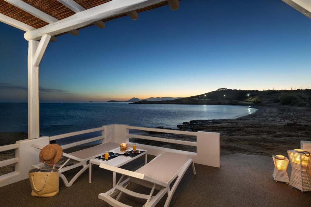 una mesa y sillas en un balcón con vistas al océano en Peter's Sea and Sαnd Residence, en Adamas