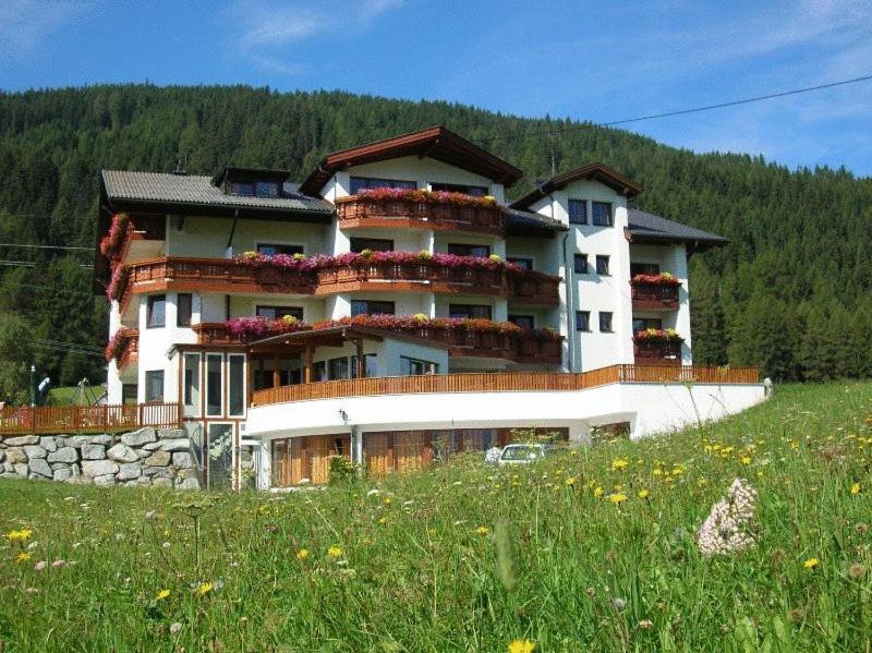 a large building on a hill with a green field at Hotel Humlerhof in Gries am Brenner
