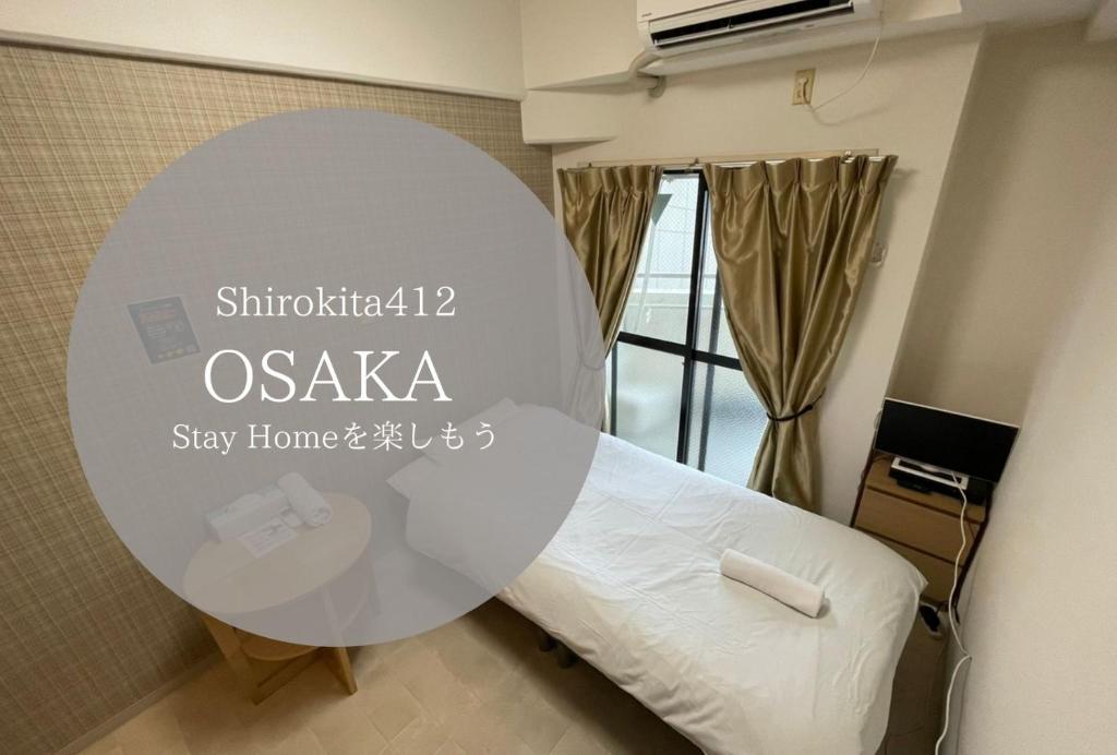 Cette chambre comprend un lit et une table ronde. dans l'établissement Exsaison Shirokita 412, à Osaka