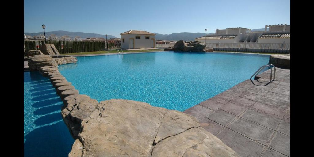 une grande piscine d'eau bleue et de rochers dans l'établissement Magnifique maison entre mer et montagne, à Alicante