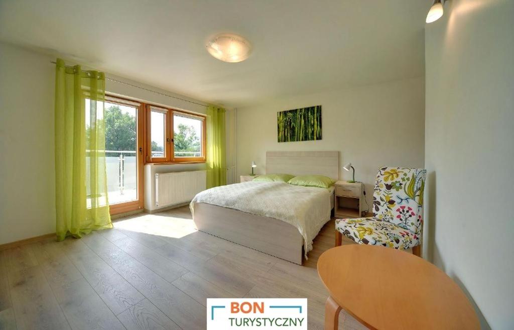 ウストロンにあるApartamenty Centrum - Sun Seasons 24のベッドルーム1室(ベッド1台、椅子、窓付)