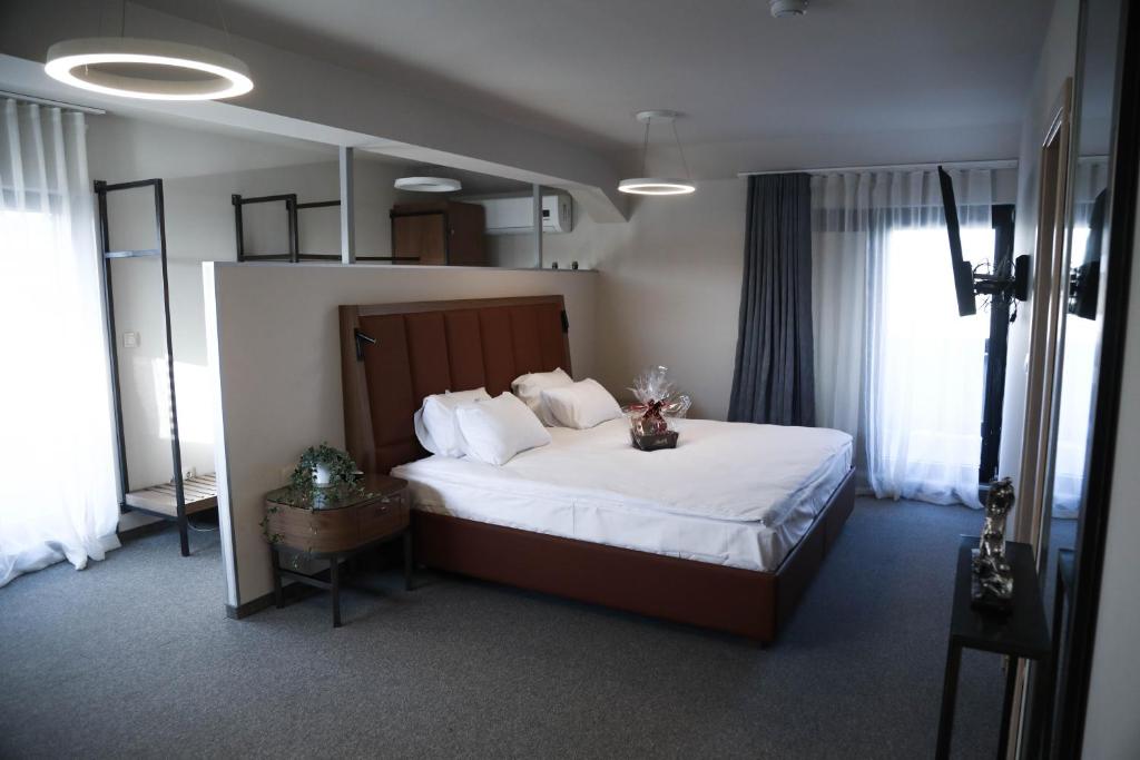 een slaapkamer met een groot bed met witte lakens bij Hotel Kanyon in Sofia