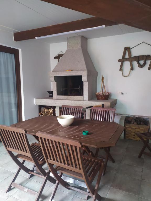 a wooden table and chairs in a room with a fireplace at O Pazo in O Grove