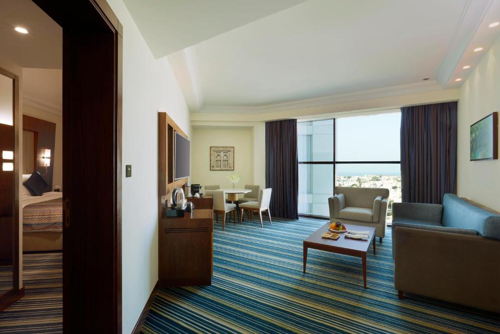a hotel room with a couch and a living room at Royal Tulip Muscat in Muscat