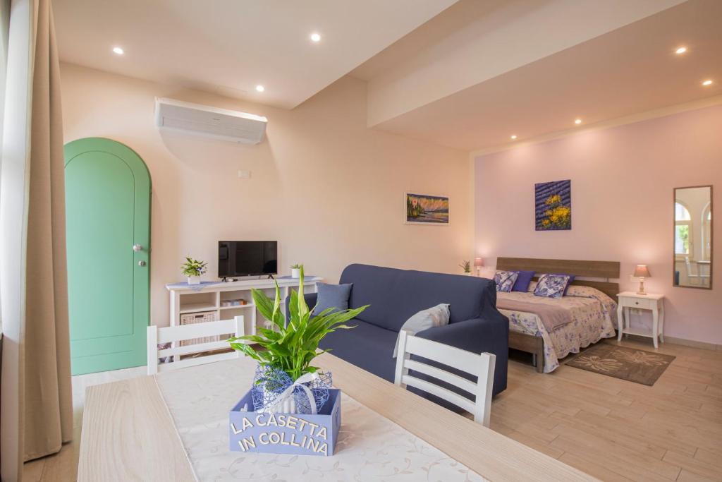 een woonkamer met een bank en een bed bij La casetta in collina in Valeggio sul Mincio
