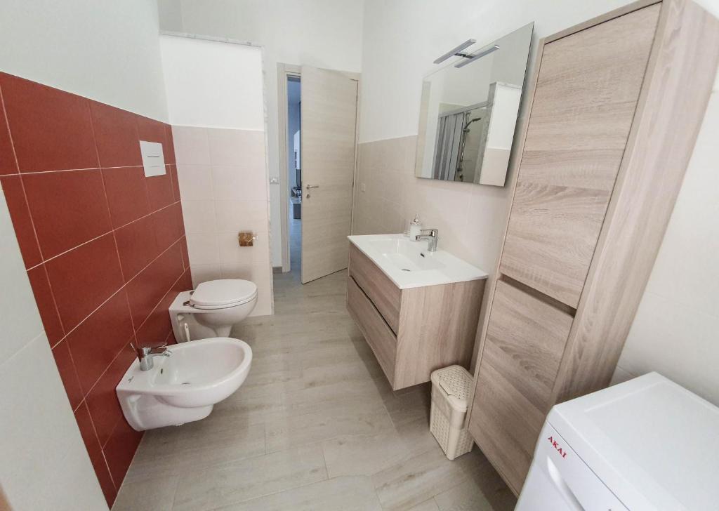 łazienka z umywalką, toaletą i lustrem w obiekcie Casa Orfeo w mieście Marina di Ragusa