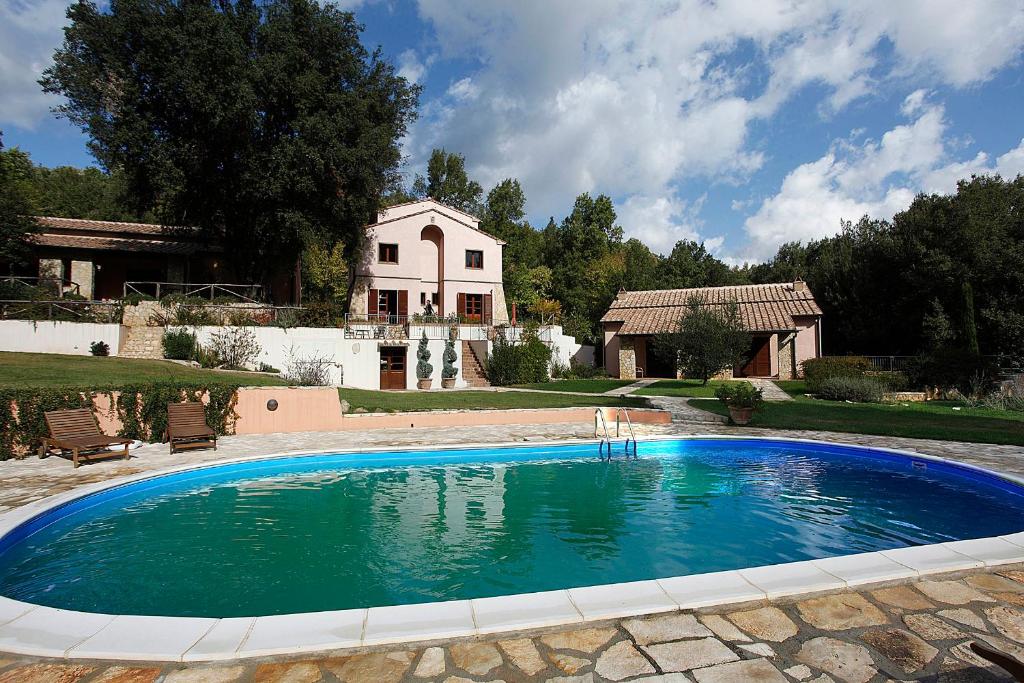 una grande piscina di fronte a una casa di Appartamento Il Leccio Pian delle more a Sassetta