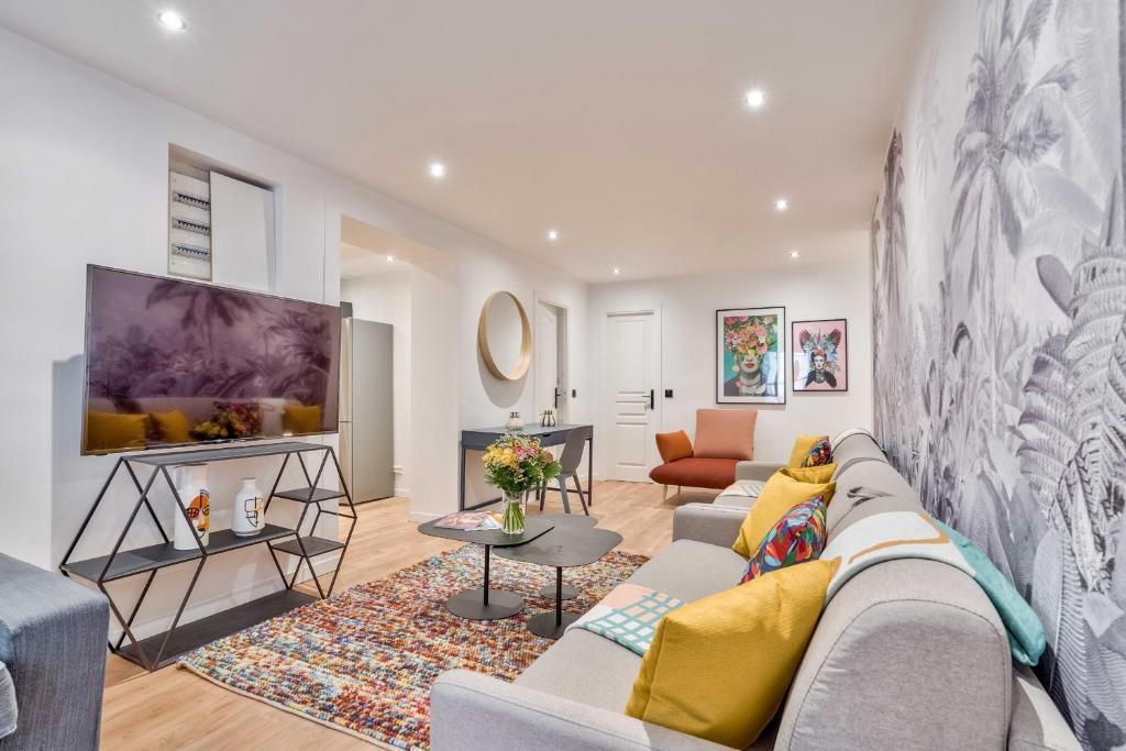 un salon avec un canapé et une télévision dans l'établissement 103 - Urban Grands Boulevards, à Paris