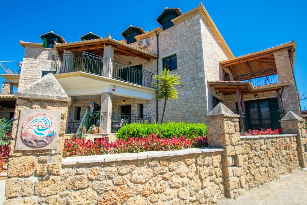 ein Haus mit einer Steinmauer in der Unterkunft Ammos Zante Villas in Vasilikos