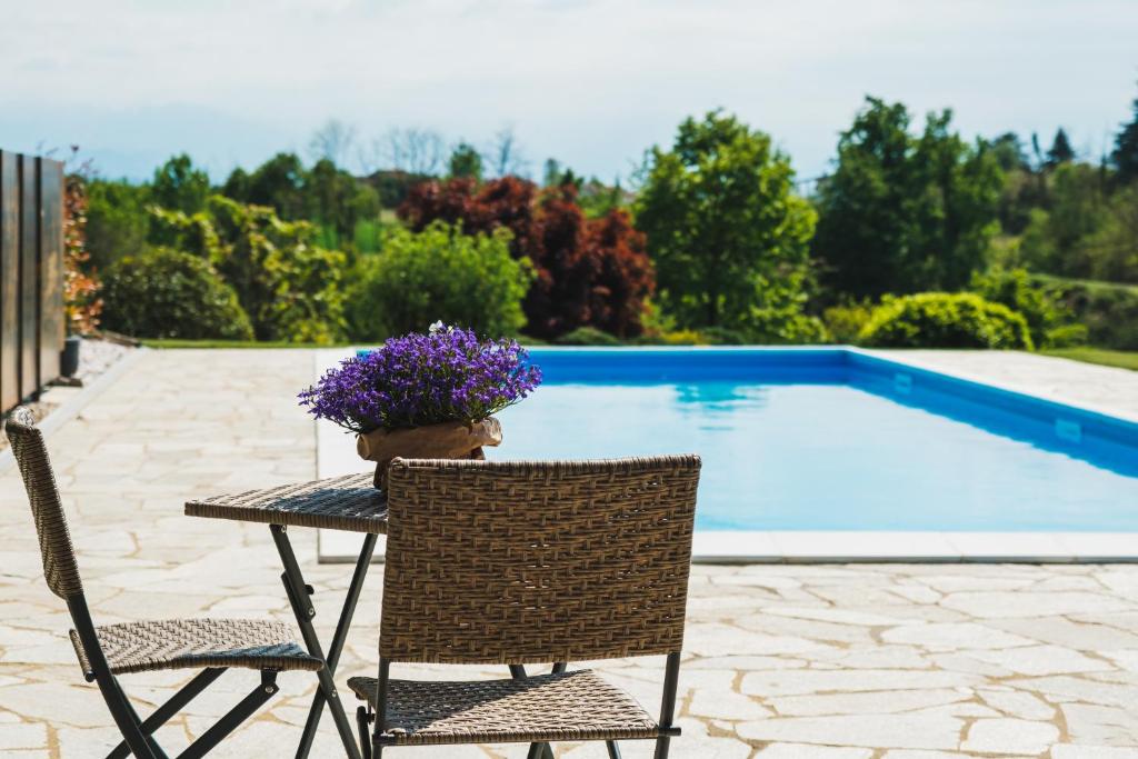 een tafel met bloemen naast een zwembad bij Il casotto nelle Langhe in Farigliano