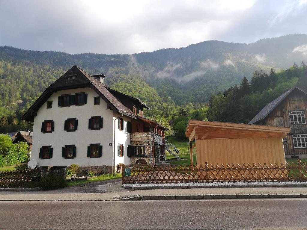 a large white house with a mountain in the background at Apartment Haider 2 in Obertraun