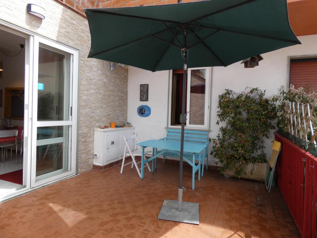 - un parasol vert sur une terrasse avec une table dans l'établissement Casa Alice, à La Spezia