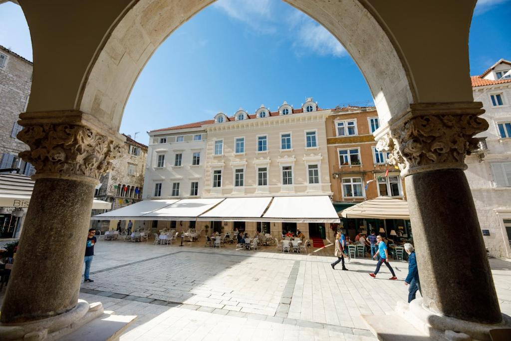 łuk w mieście z ludźmi chodzącymi po ulicy w obiekcie Heritage hotel Santa Lucia w Splicie