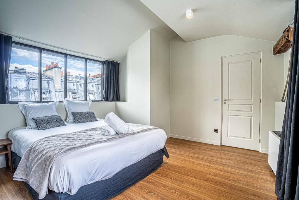 a bedroom with a large bed and a large window at 135 - Urban Five Star Apartment in Center of Paris in Paris