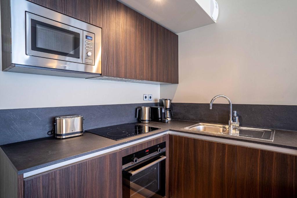 a kitchen with a sink and a microwave at 135 - Urban Five Star Apartment in Center of Paris in Paris