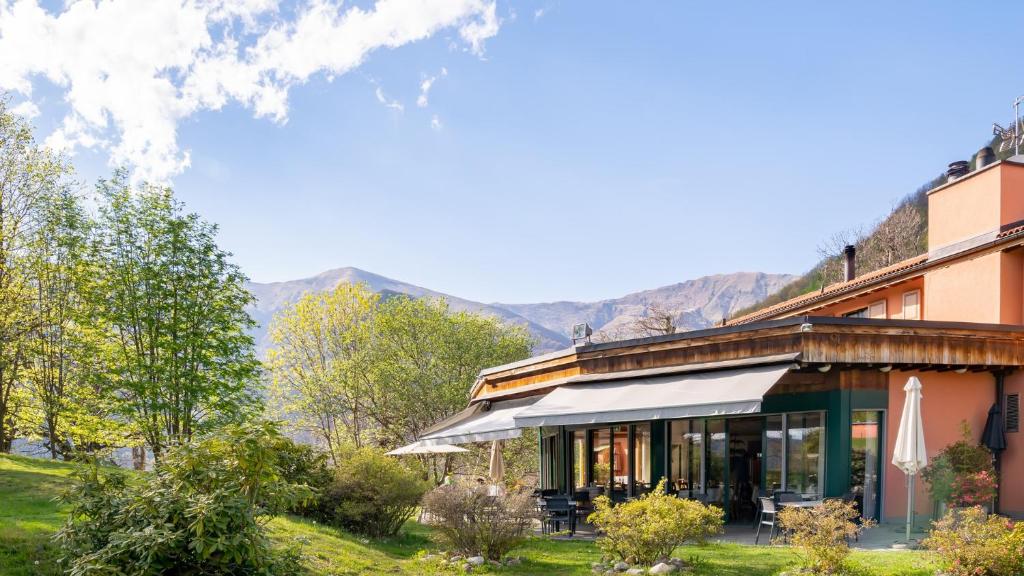 a building with mountains in the background at Hotel Il Castagno in Mugena