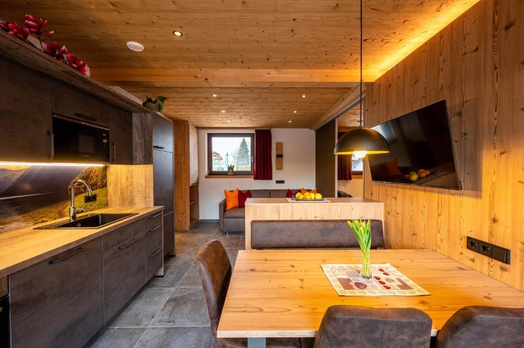 a kitchen and dining room with a wooden table at Chalet Auszeit in Lermoos