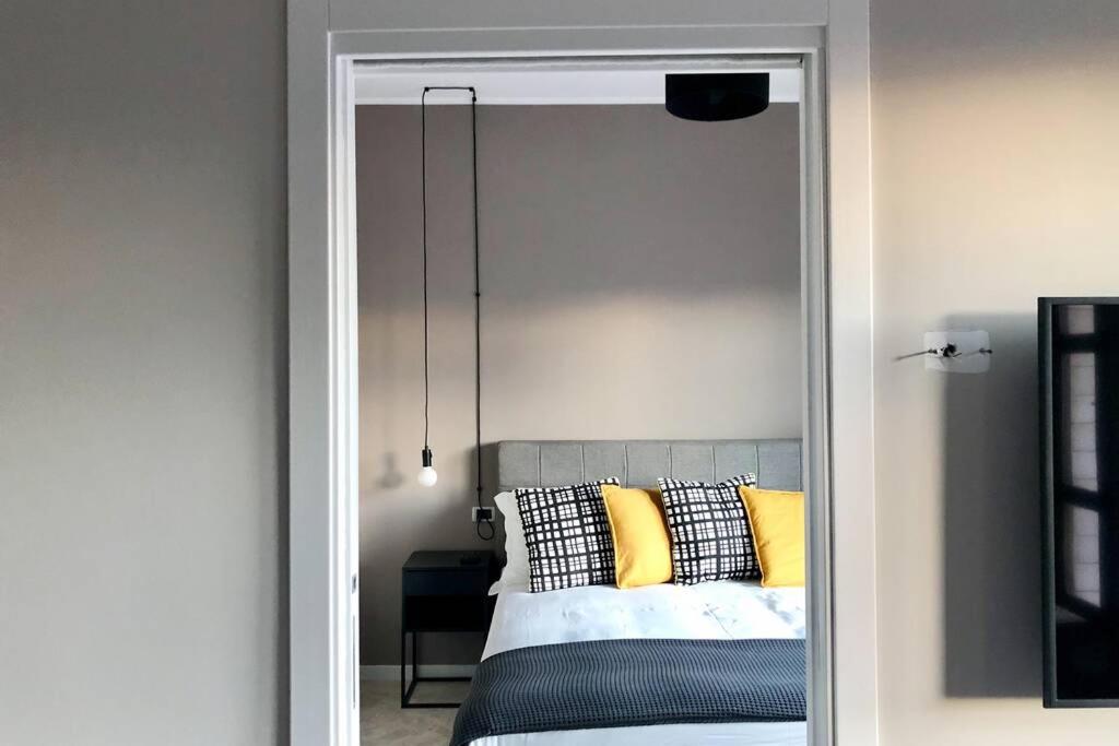 ein Schlafzimmer mit einem Bett mit gelben Kissen und einem Spiegel in der Unterkunft laus via sparano - lux & design mini in Bari