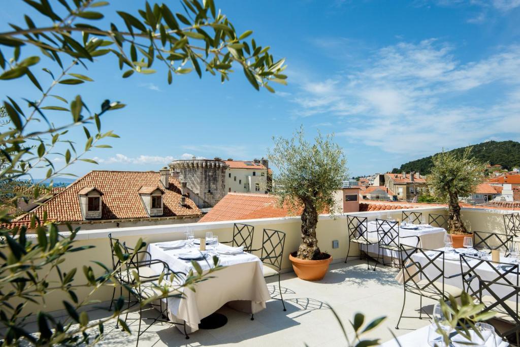 a patio with tables and chairs on the roof of a building at Heritage hotel Santa Lucia in Split