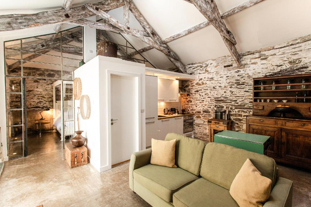 a living room with a couch and a stone wall at ANRÁN at Tidwell Farm in Staverton