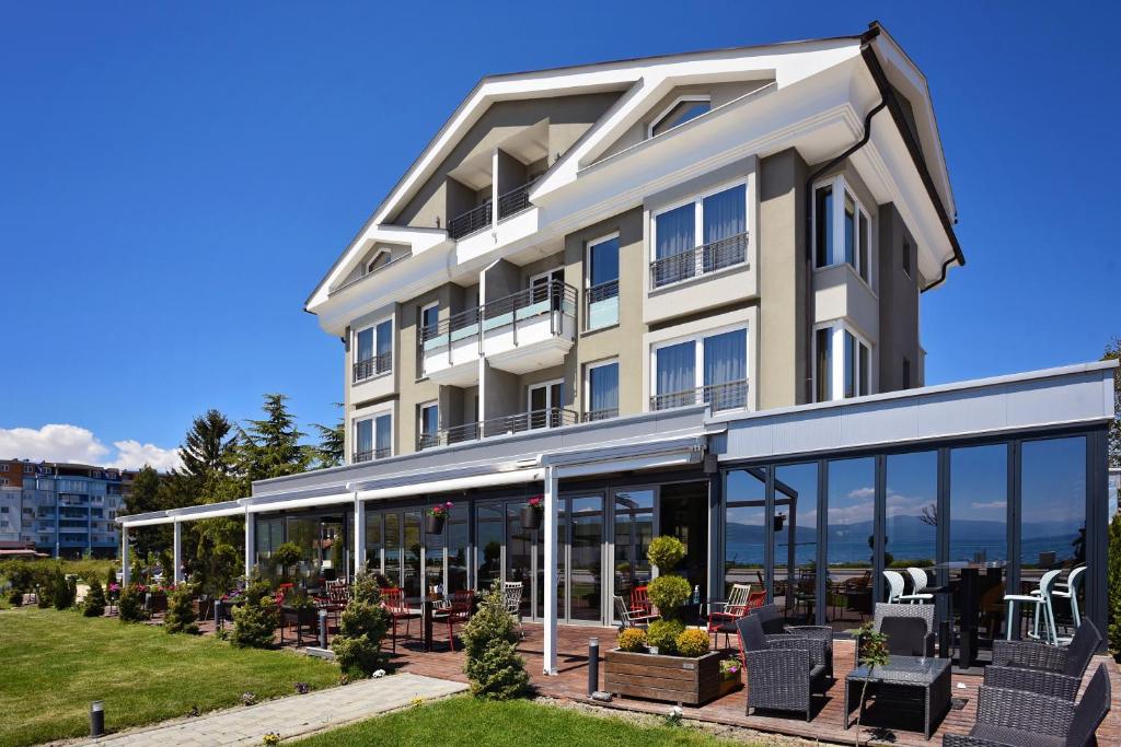 un gran edificio blanco con puertas y ventanas de cristal en Vila Europa, en Struga