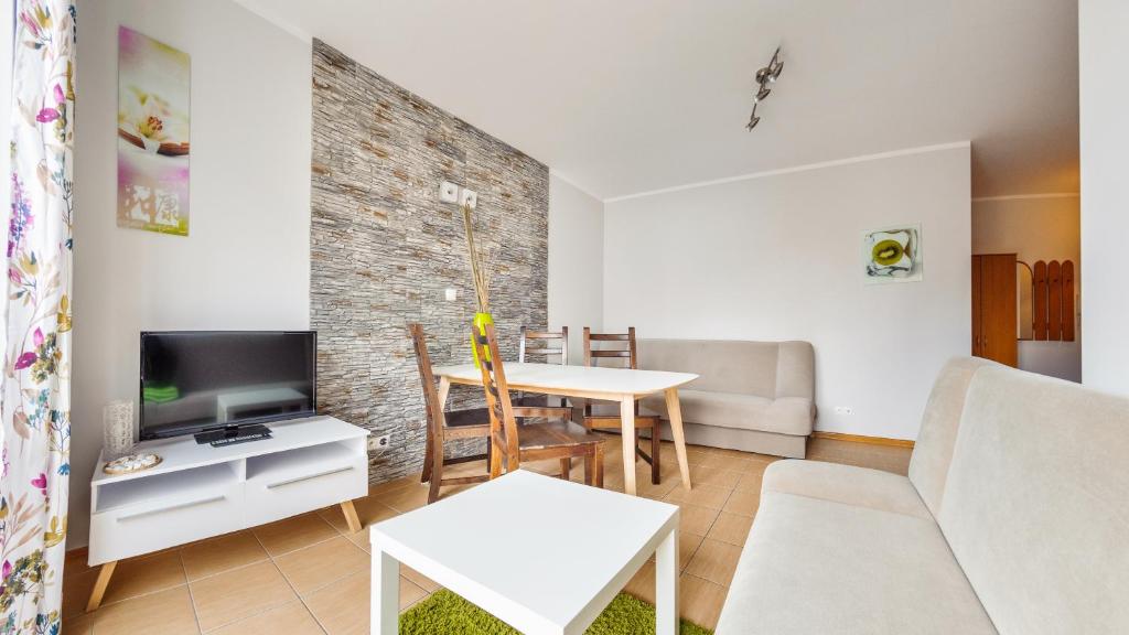 a living room with a couch and a table at Apartamenty Sun & Snow Mierzeja Park in Sztutowo