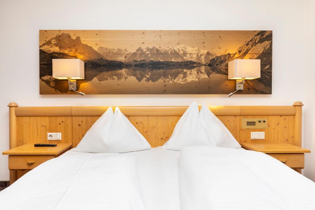 sypialnia z białym łóżkiem z 2 lampami w obiekcie Hotel Pongauerhof w mieście Flachau