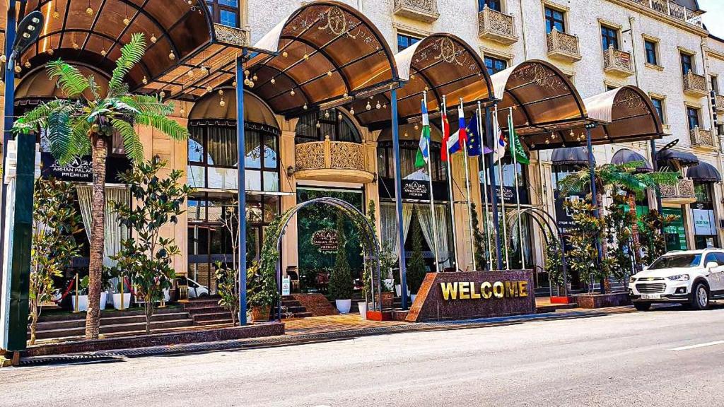 un bâtiment avec un panneau de bienvenue devant lui dans l'établissement Hotel Arhan Palace, à Samarcande