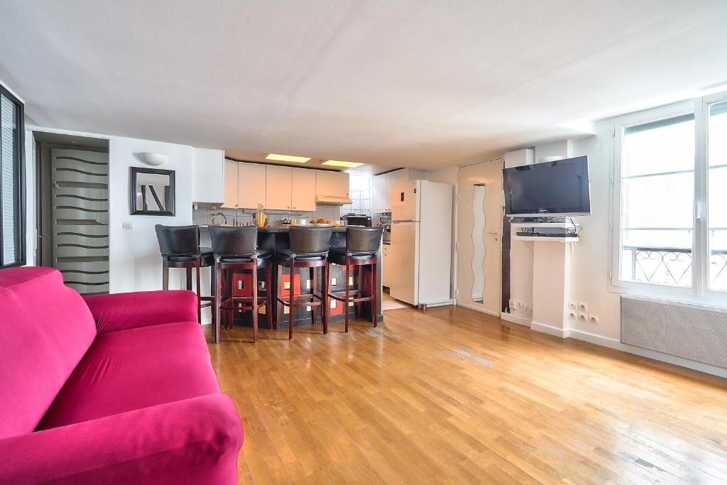 Il comprend un salon avec un canapé rouge et une cuisine. dans l'établissement The Perfect Parisian 2 bdrs flat at Le Marais, à Paris