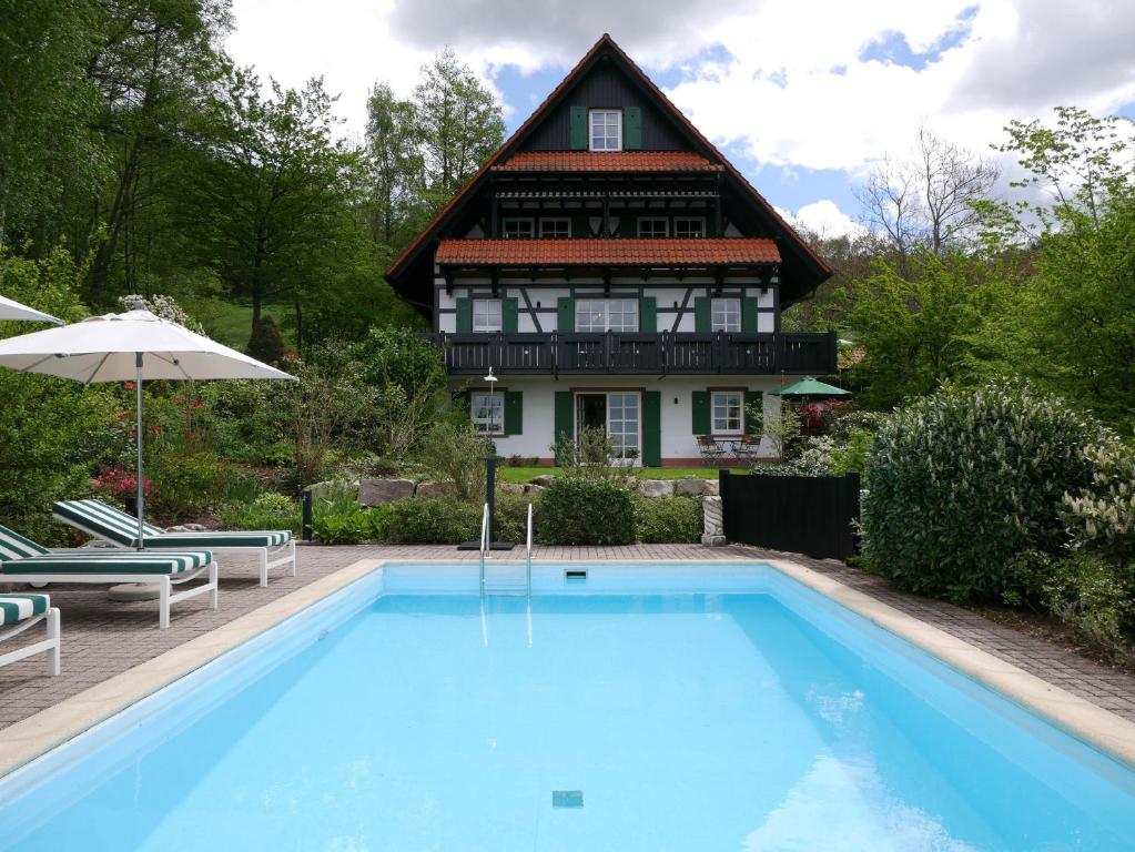 una casa con piscina frente a una casa en Ferienhaus Straubehof-Spengler, en Sasbachwalden