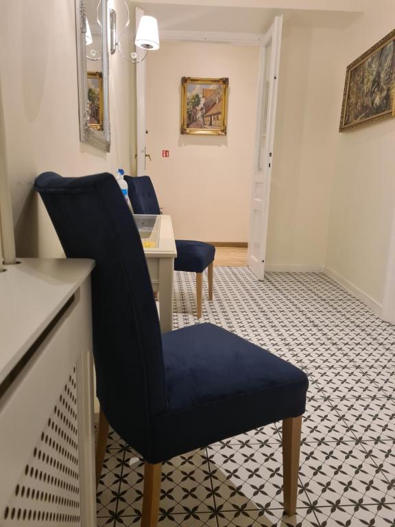 a waiting room with a blue chair and a table at AMBER APARTAMENT 1112 in Krakow