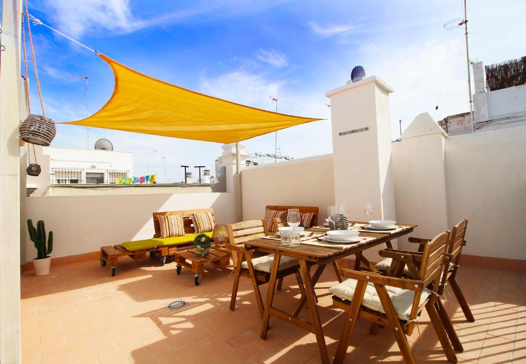 patio ze stołem i krzesłami na dachu w obiekcie Ático de la Luz w Kadyksie