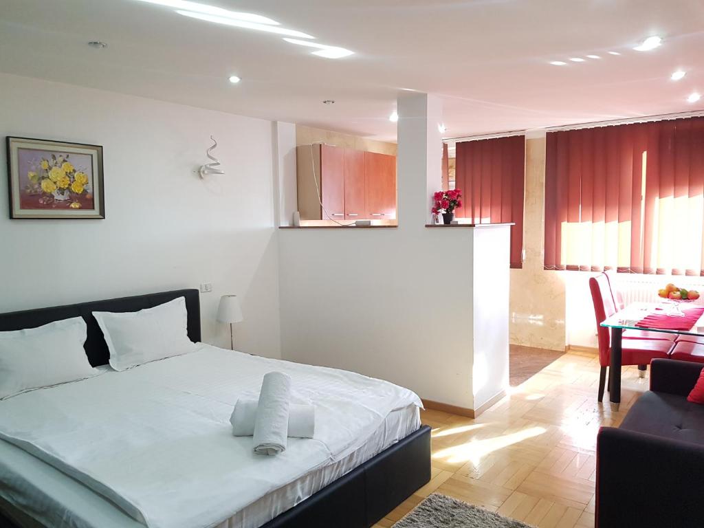 a bedroom with a bed and a living room at Apartament Gomoiu Monza Arena Nationala in Bucharest