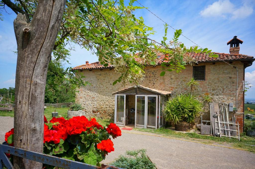 ein Haus mit roten Blumen davor in der Unterkunft B&B Parco dei cavalli in Castel San Pietro Terme