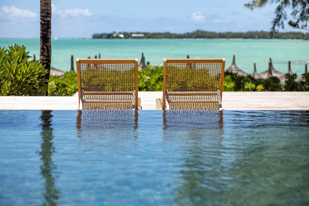 - deux chaises assises dans une piscine d'eau dans l'établissement Lagoon Attitude (Adults Only), à Cap Malheureux