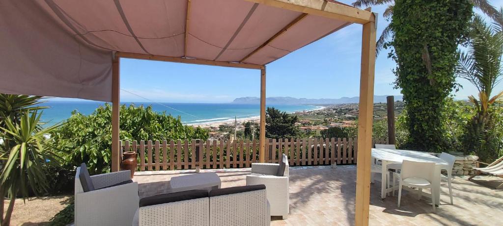 patio ze stołem i krzesłami oraz oceanem w obiekcie Villa Anna, con patio vista mare w mieście Castellammare del Golfo