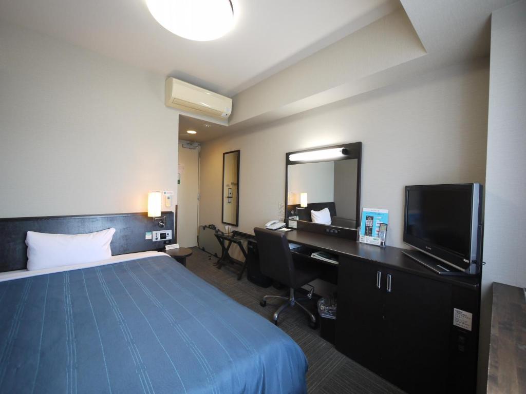 Un pat sau paturi într-o cameră la Hotel Route-Inn Nanao Ekihigashi