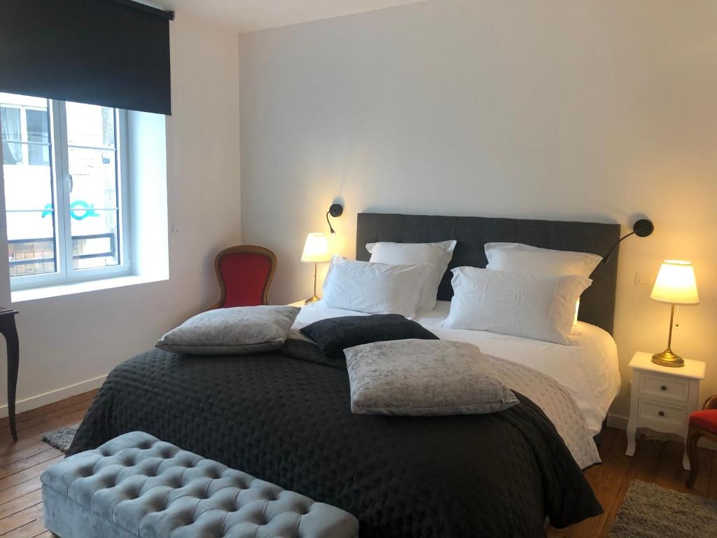 una camera da letto con un grande letto con due cuscini di L'Otentik Restaurant Chambres d'Hôtes a Rosporden