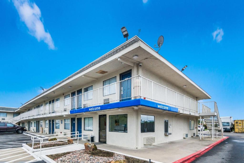 a white building with a blue stripe on it at Motel 6-Irving, TX - Dallas in Irving
