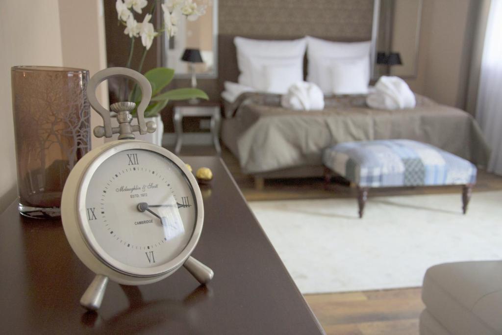 a clock sitting on a table in a bedroom at Willa Sepia SPA in Wisła