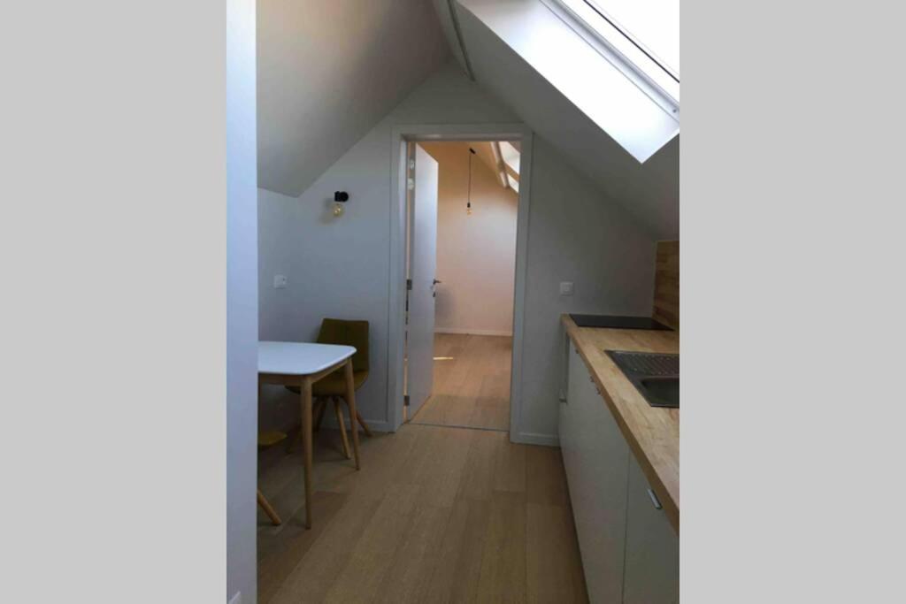 an attic kitchen with a skylight and a table at StudiO2 Ename, dakappartement in Vlaamse Ardennen in Oudenaarde