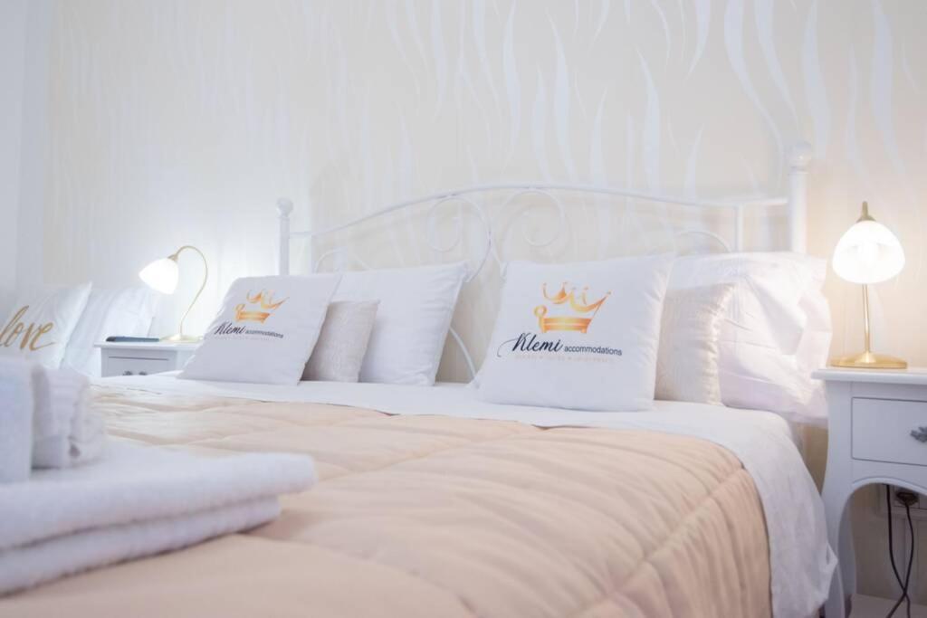 a white bedroom with two white beds with crown pillows at Appartamento in pieno centro a Trento in Trento