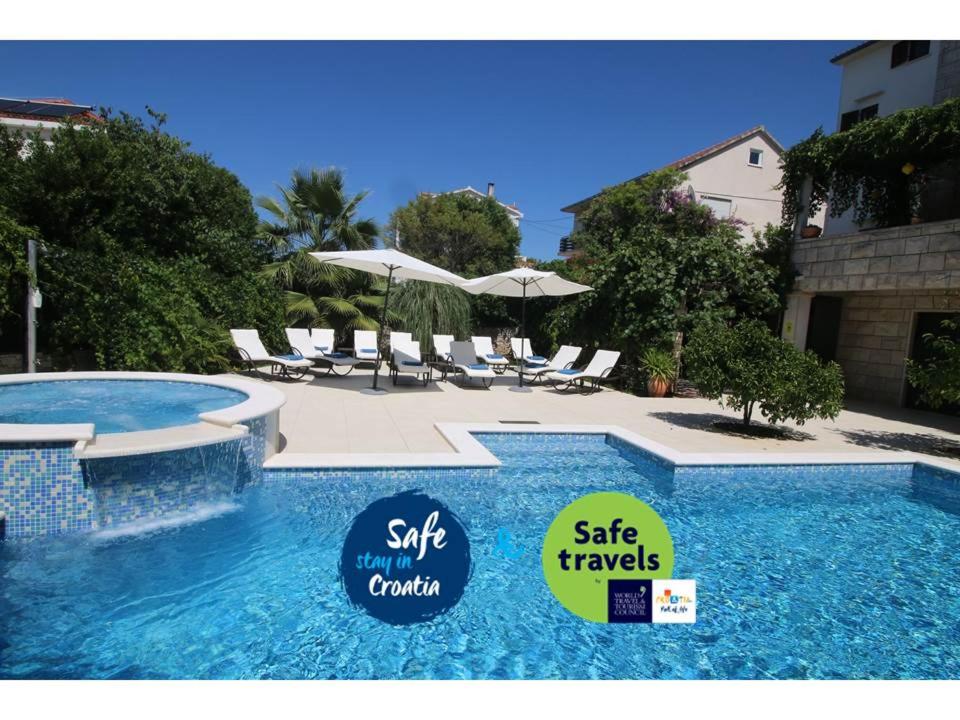 ein großer Pool mit Stühlen und Sonnenschirmen in der Unterkunft Villa Renipol Adults only in Sutivan
