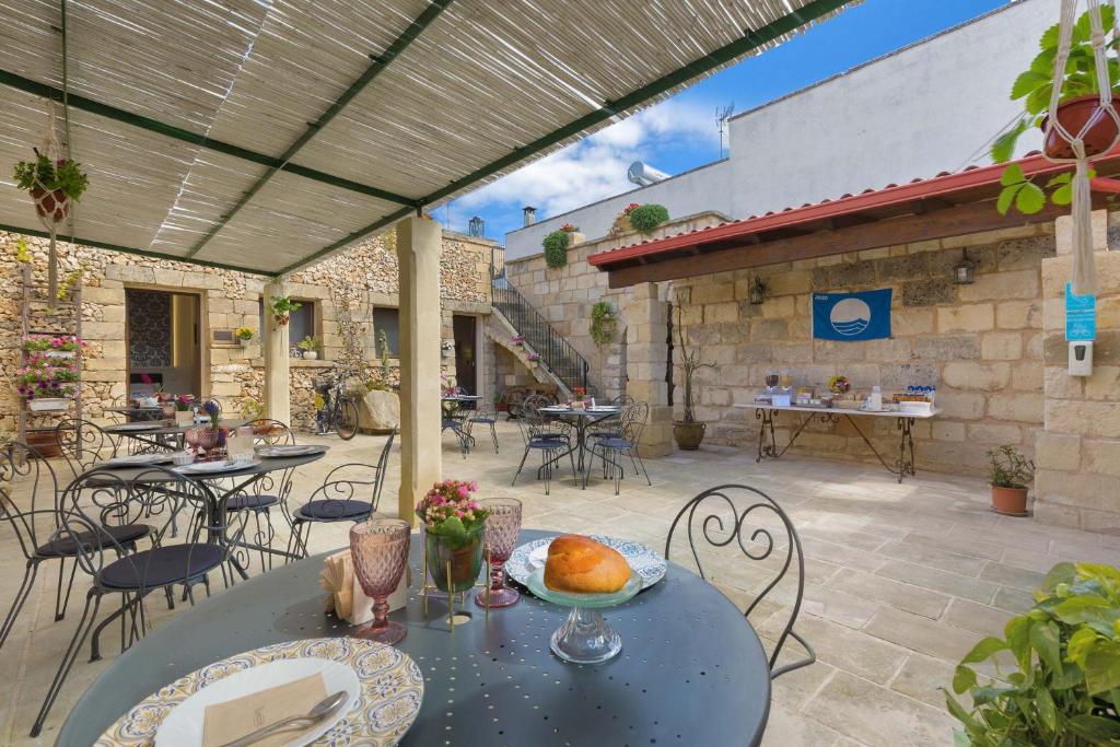 a patio with tables and chairs and a building at Salento Ada's House in Melendugno