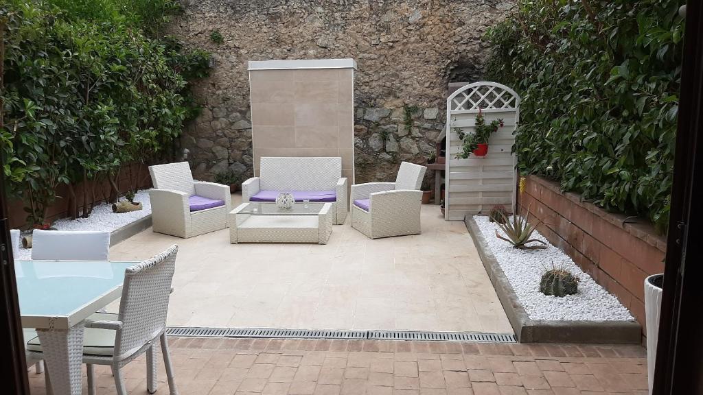 a patio with white chairs and a table at Villa Oscar in Tropea