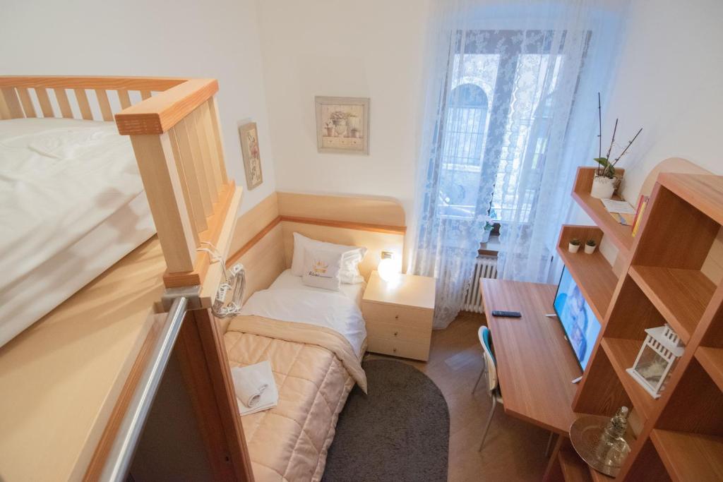 Habitación pequeña con cama y escritorio. en Appartamento accanto ai Mercatini di Natale, en Trento