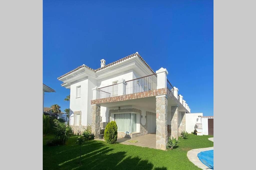 een groot wit huis met een balkon en een tuin bij Comfortable house with private pool and great view in La Mairena