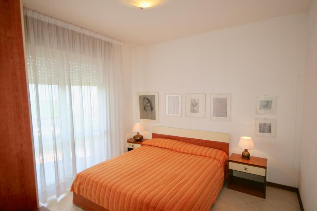 リニャーノ・サッビアドーロにあるBA- LA TORRE - Sea View -の白いベッドルーム(ベッド1台、ランプ2つ付)